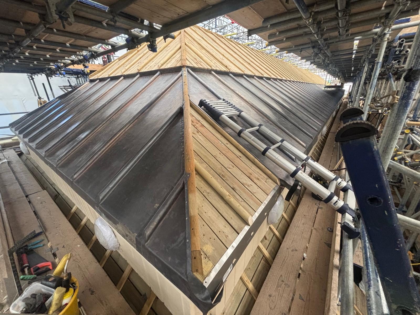 Lead pyramid roof with wood-roll courses